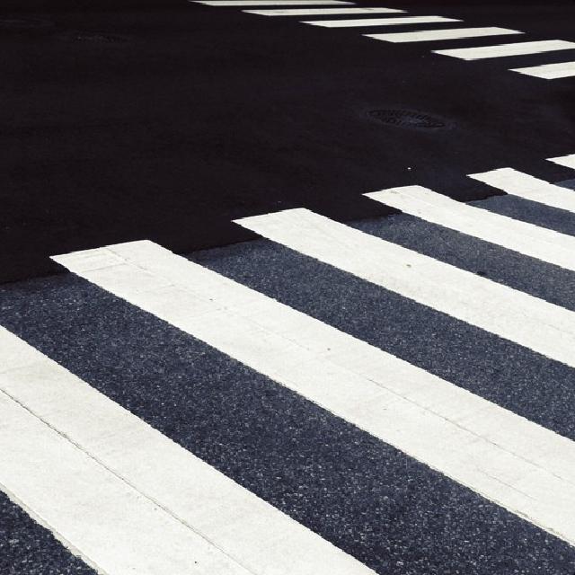 Overgangsfelt i sterk kontrast mot sort asfalt.