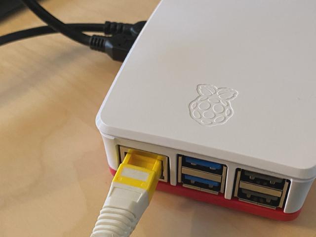 Min første hjemmeserver Nærbilde av Raspberry Pi 5 med nettverkskabel koblet i.