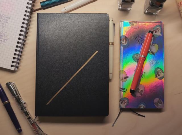 To notatbøker for 2026 blant penner og blekk.