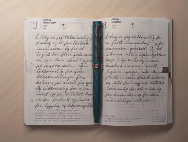 Journalen oppslått med en fyllepenn liggende i midten.