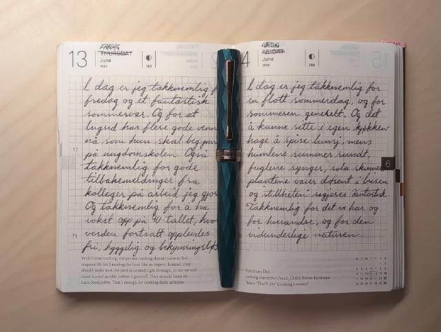 Journalen oppslått med en fyllepenn liggende i midten.